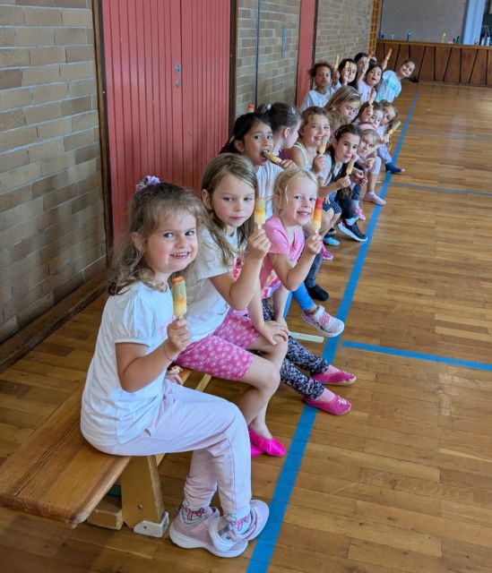Unsere Tanzmäuse sitzen in der Turnhalle auf der Bank uns schlecken Eis