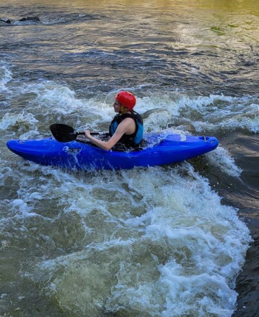 Ein Kanute im blauen Kajak und rotem Helm auf der Günz