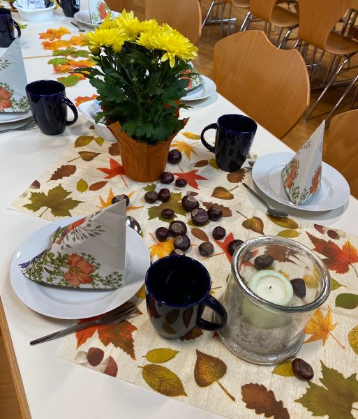 Dekorierter Tisch mit Herbstastern, Kastanien und Blättern